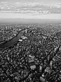 Aerial view of buildings against cloudy sky in city