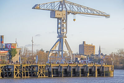 Ferris wheel by pier against sky