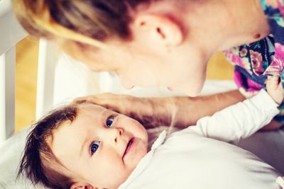 Side view of mother playing with daughter at home