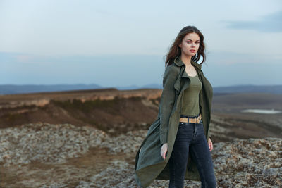 Young woman standing against sea