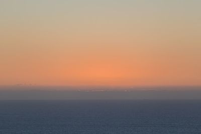 Scenic view of sea against clear sky during sunset