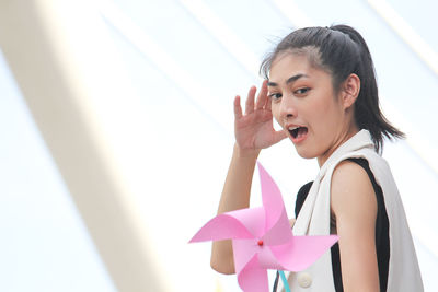 Young woman pinwheel toy against white background