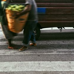 Low section of man walking on street