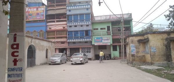 Cars on road by buildings in city