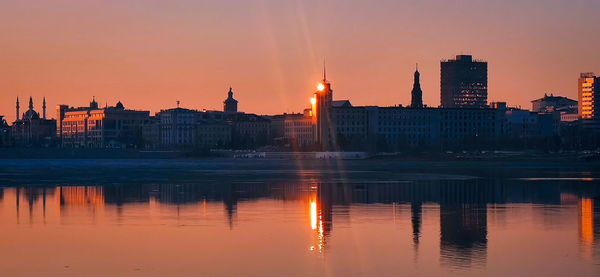 Reflection of illuminated city at sunset