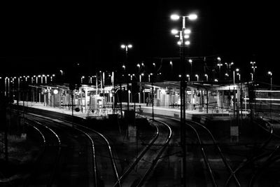 Railroad tracks against sky at night