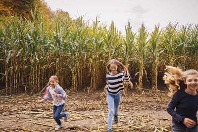 Girls playing while running in corn field