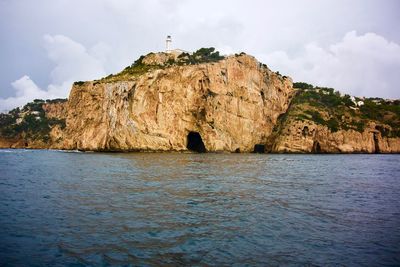 Rock formations by sea against sky