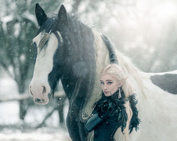 Young woman with horse in snow