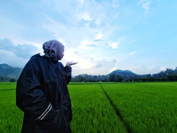 Man standing in field against sky