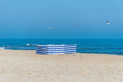 Beach screen on the polish beach on a sunny summer day in the background beautiful sea and gulls