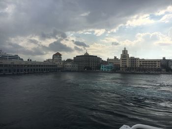 Buildings in city against cloudy sky