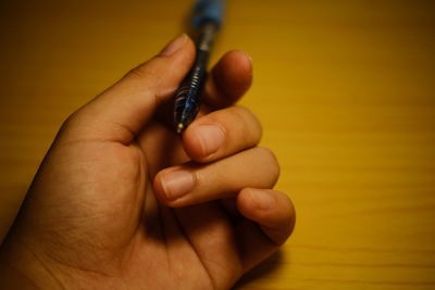 Close-up of human hand holding wood