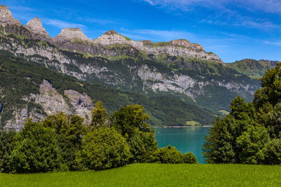 Scenic view of lake and mountains against blue sky