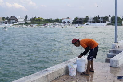 Man working on retaining wall by sea