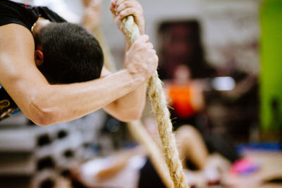 Close-up of man holding rope at gym