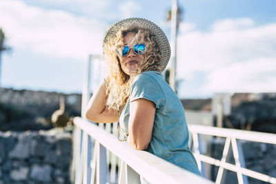 Portrait of boy wearing sunglasses standing against railing