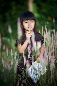 Cute girl standing amidst plants