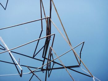 Low angle view of power lines against clear blue sky