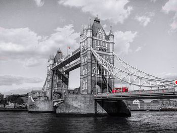 Low angle view of suspension bridge against cloudy sky
