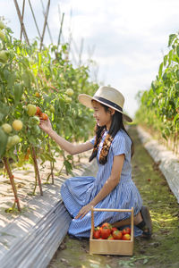 Full length of young woman holding strawberry outdoors