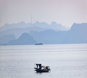 Boat in sea against mountain range