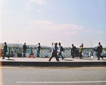 People walking on road against sky