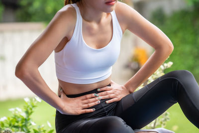 Midsection of woman sitting outdoors