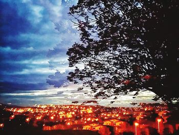 Illuminated city against sky at night