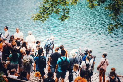 High angle view of people on footbridge by lake