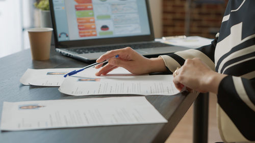 Midsection of businessman working on table