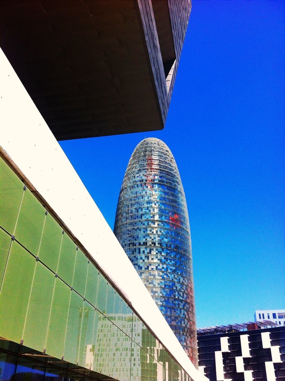 architecture, built structure, blue, building exterior, low angle view, clear sky, city, modern, office building, building, skyscraper, outdoors, day, famous place, sunlight, architectural feature, copy space, tall - high, capital cities, city life