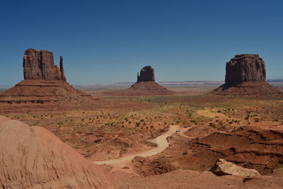 Scenic view of rock formations in monument valley against clear blue sky