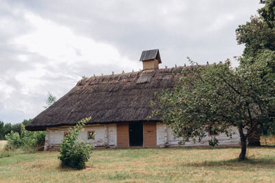 Old house on field against sky