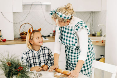Mom teaches her daughter to bake christmas gingerbread and cookies. christmas spirit