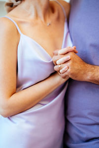 A man and a woman are holding hands. monotonous colors. wedding ring on the finger very puri pantone