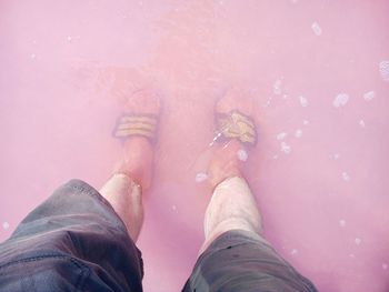 Low section of man standing in lake