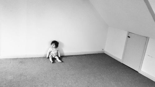 High angle view of girl looking away while sitting on floor at home