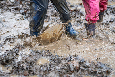 Low section of person walking in mud