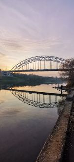 Bridge over river against sky during sunset