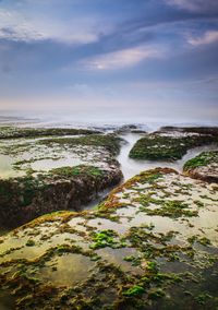 Scenic view of waterfall against sky