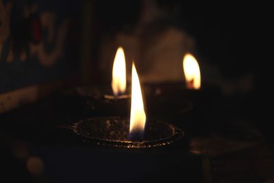 Close-up of illuminated candle light on retaining wall