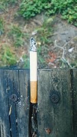 Close-up of cigarette on wooden post