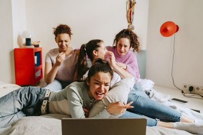 Female friends watching movie together at home