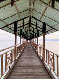 Footbridge over sea against sky