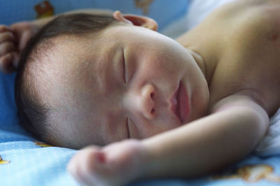 Baby sleeping on bed at home