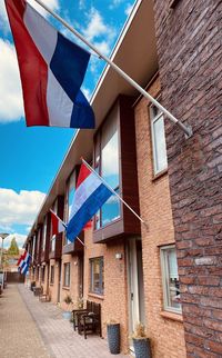 Low angle view of flags on building against sky