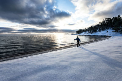 Man on sea shore against sky