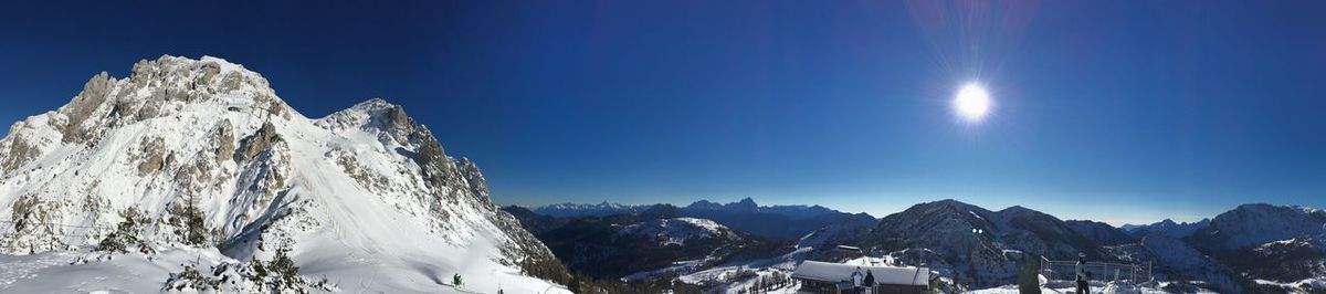 Scenic view of snowcapped mountains against blue sky