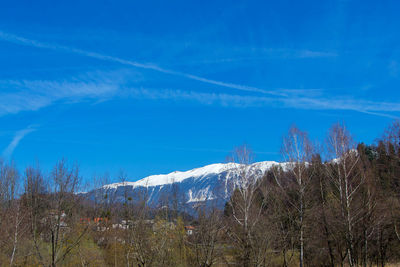 Scenic view of snowcapped mountains against blue sky